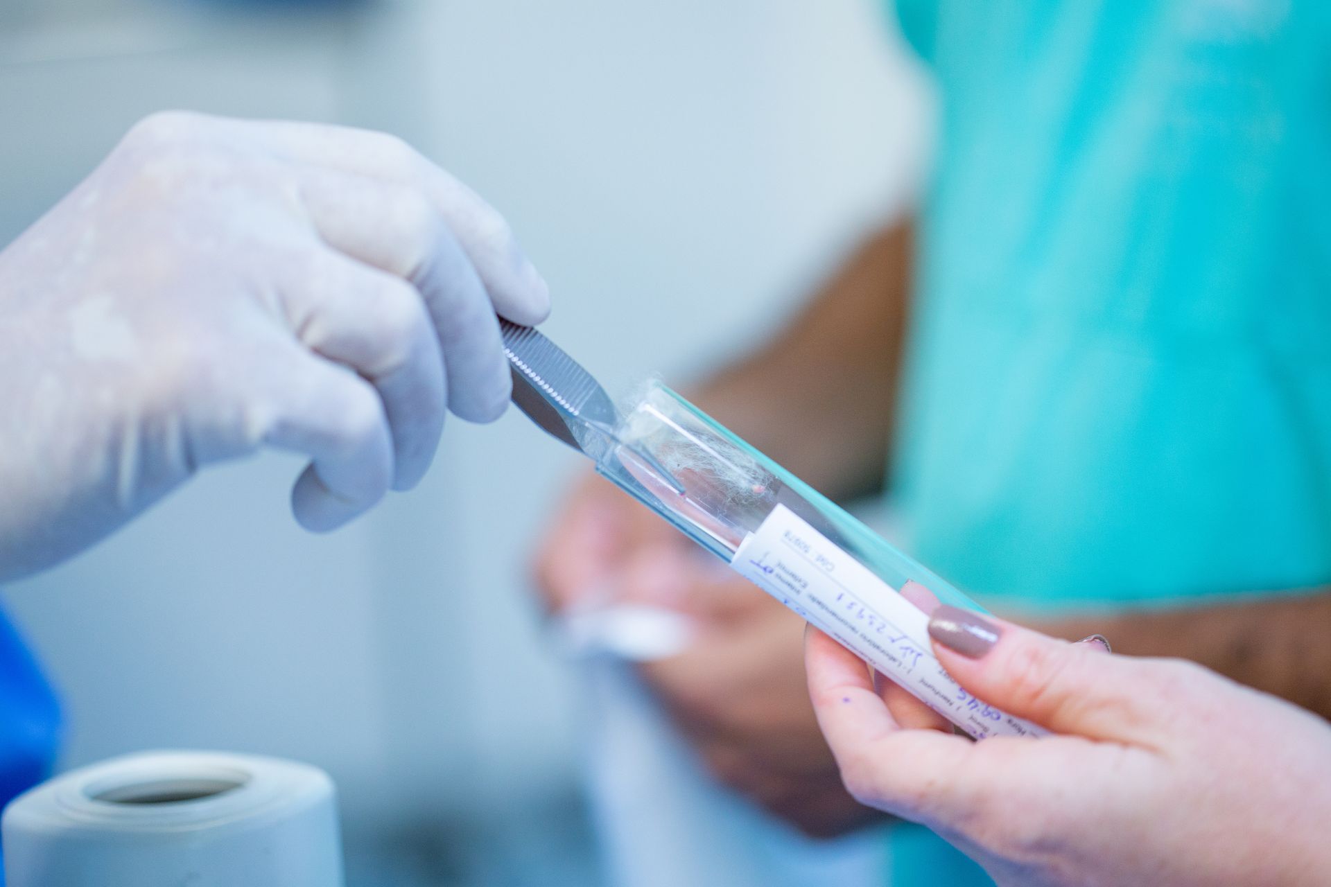 closeup of dermatologist placing biopsy sample in tube