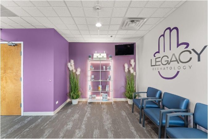 Bright lobby with purple walls, blue chairs, and Legacy Dermatology sign.