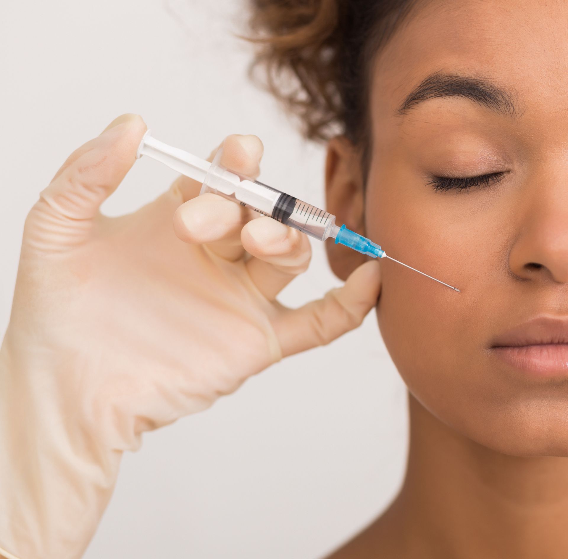 young black woman receives cosmetic facial injection