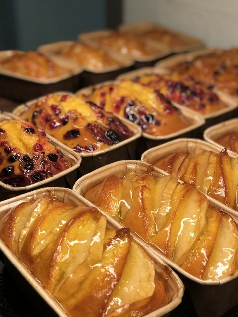 File di mini plumcake dorati ricoperti di frutta e glassati.