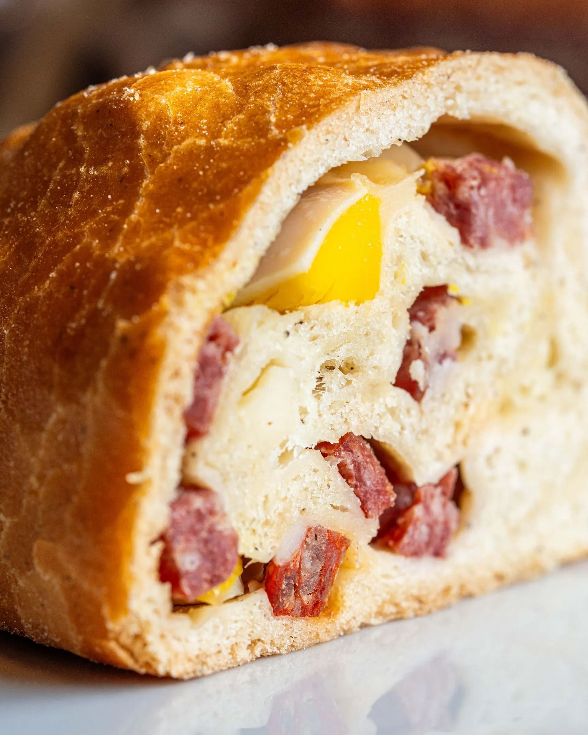 Torta salata pasquale italiana, tagliata a metà per rivelare il ripieno di uova, salsiccia e formaggio.