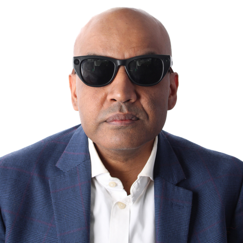 A head and shoulders picture of a man wearing a navy blue jacket, white shirt & black sun glasses