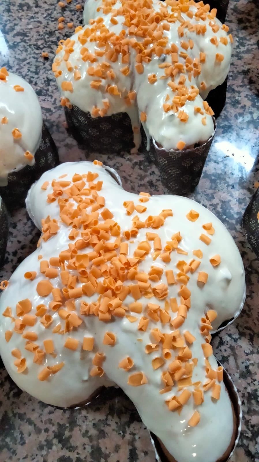 Primo piano di una torta con glassa bianca e noci su un tavolo.