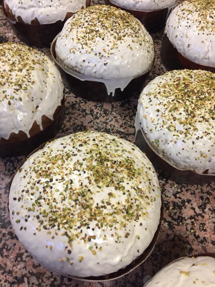 Un mucchio di cupcakes con glassa bianca e pistacchi sopra