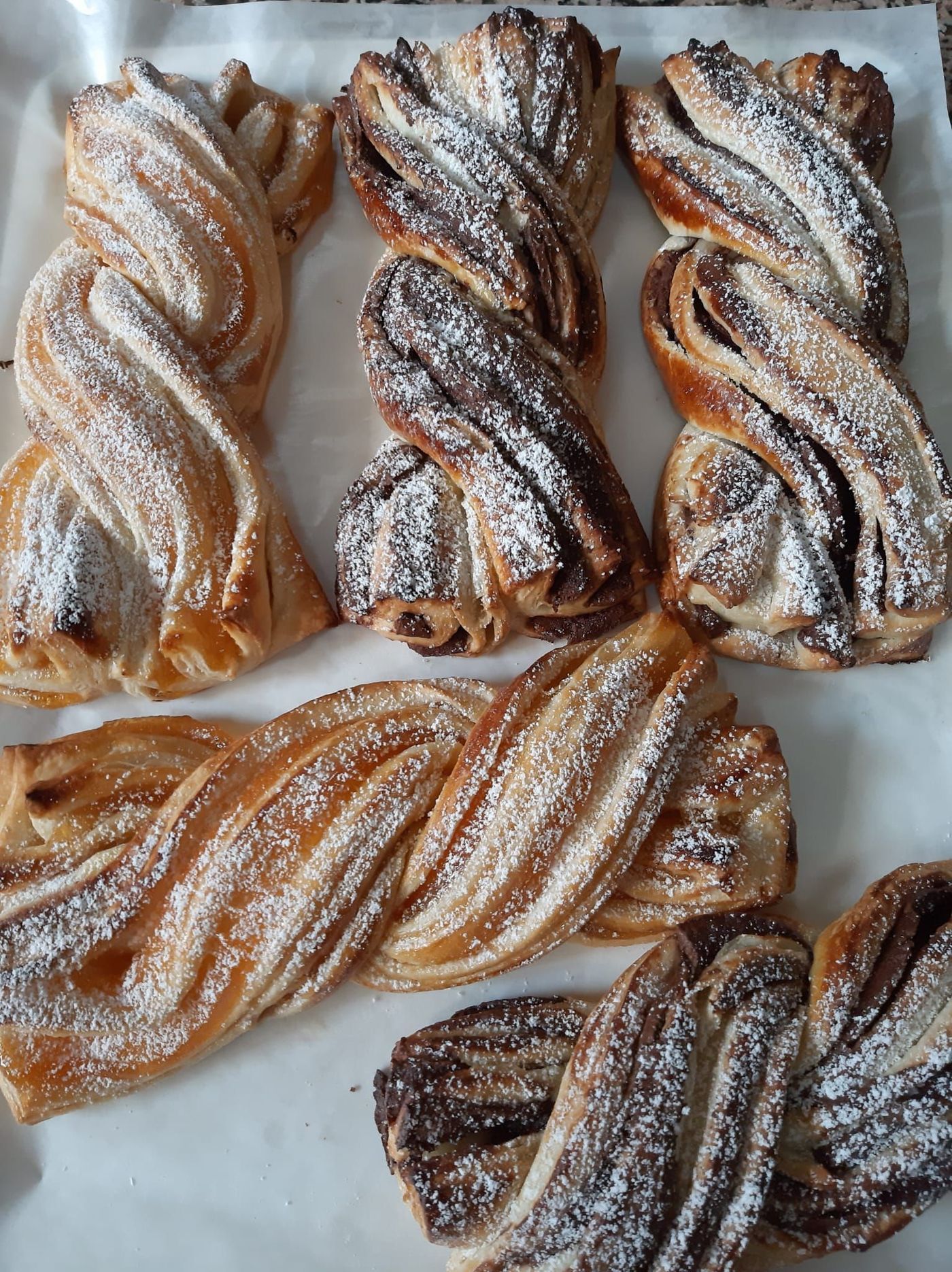 Un mucchio di pasticcini intrecciati ricoperti di zucchero a velo