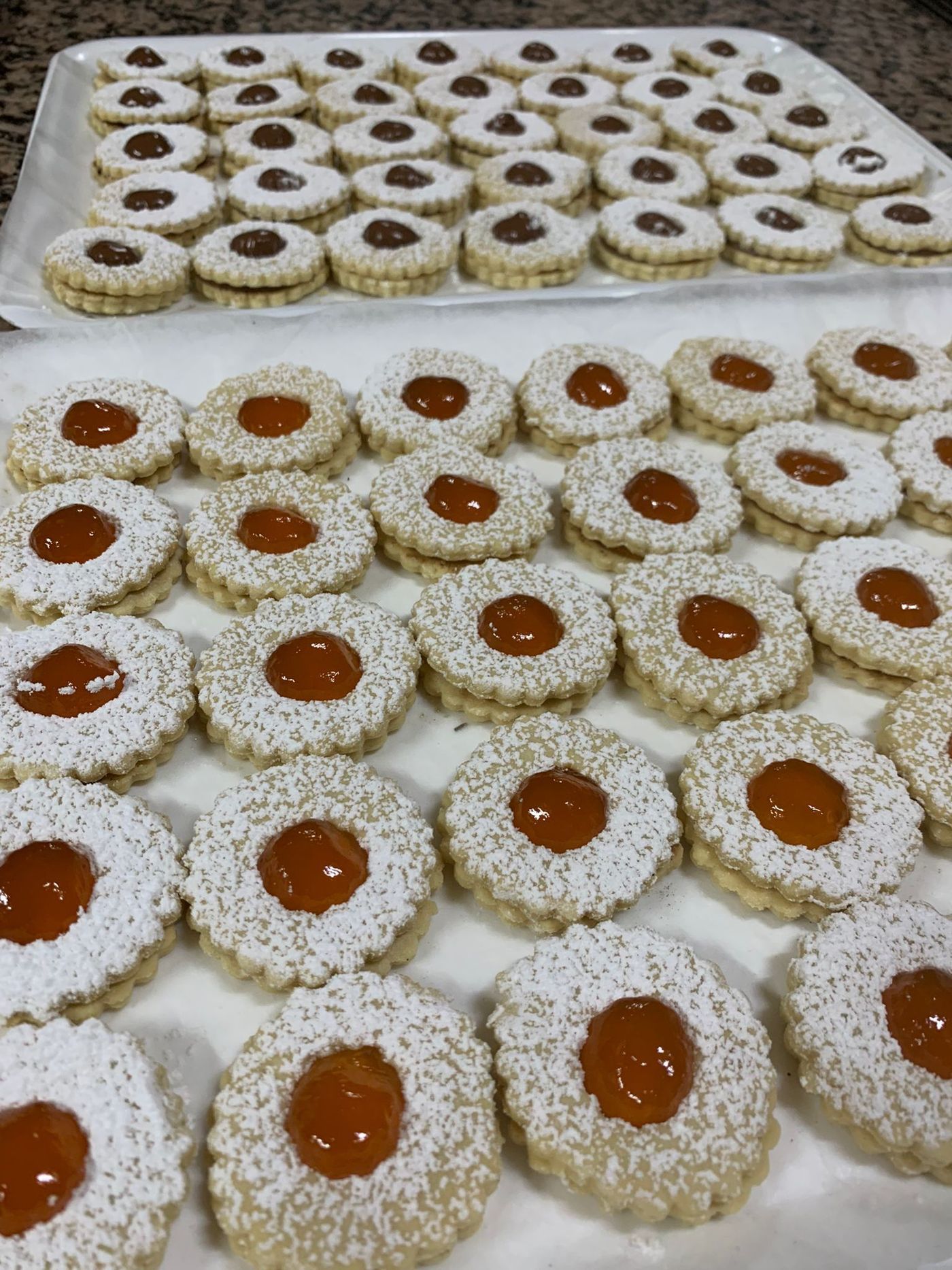 Un vassoio di biscotti con zucchero a velo e marmellata sopra