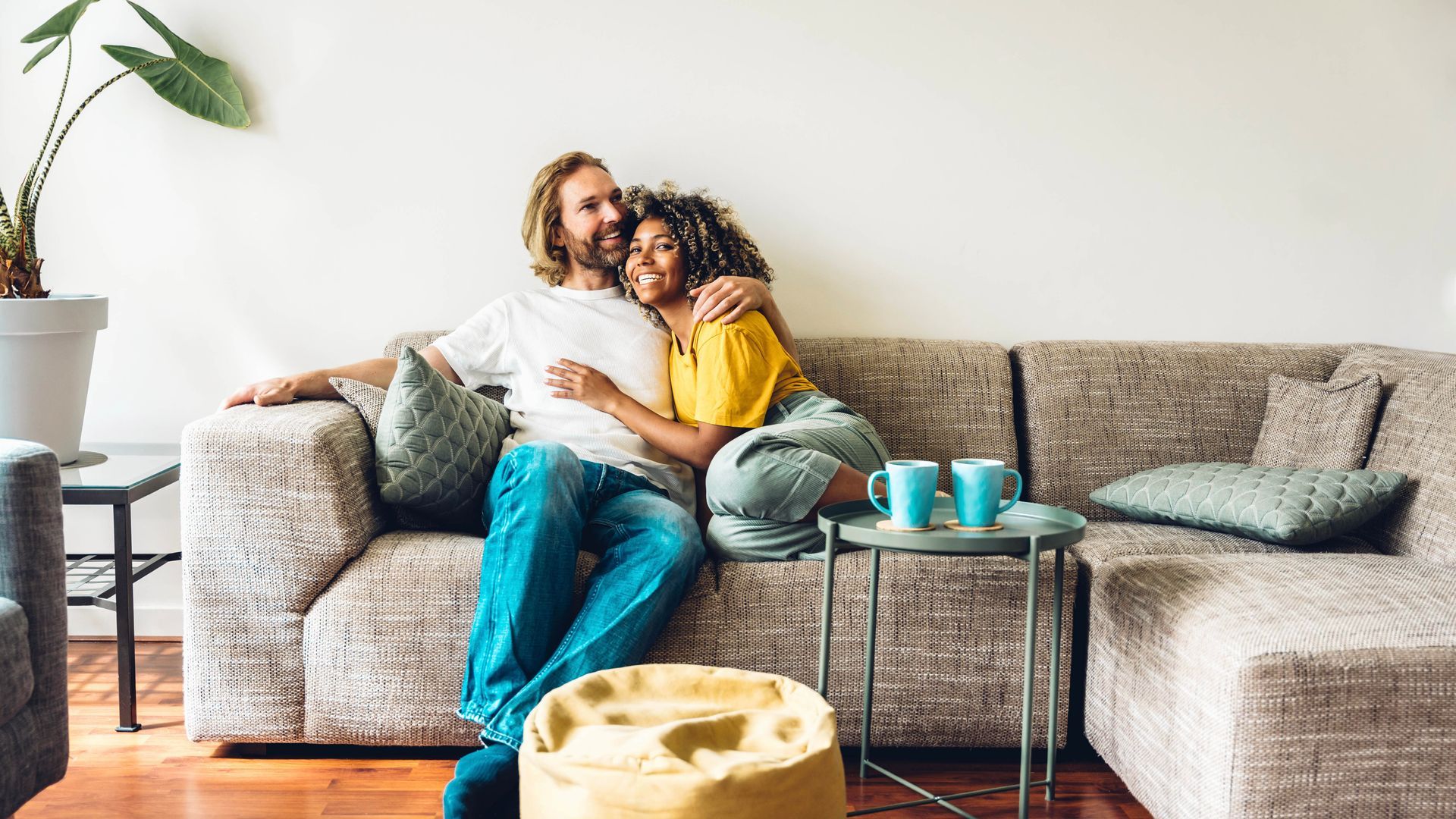 A man and a woman are sitting on a couch in a living room.