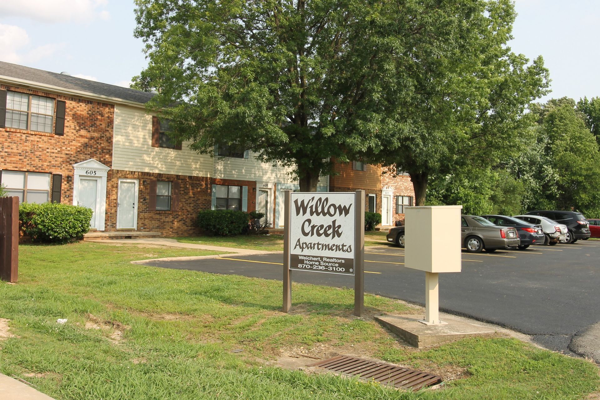 A sign in front of a building that says willow creek apartments