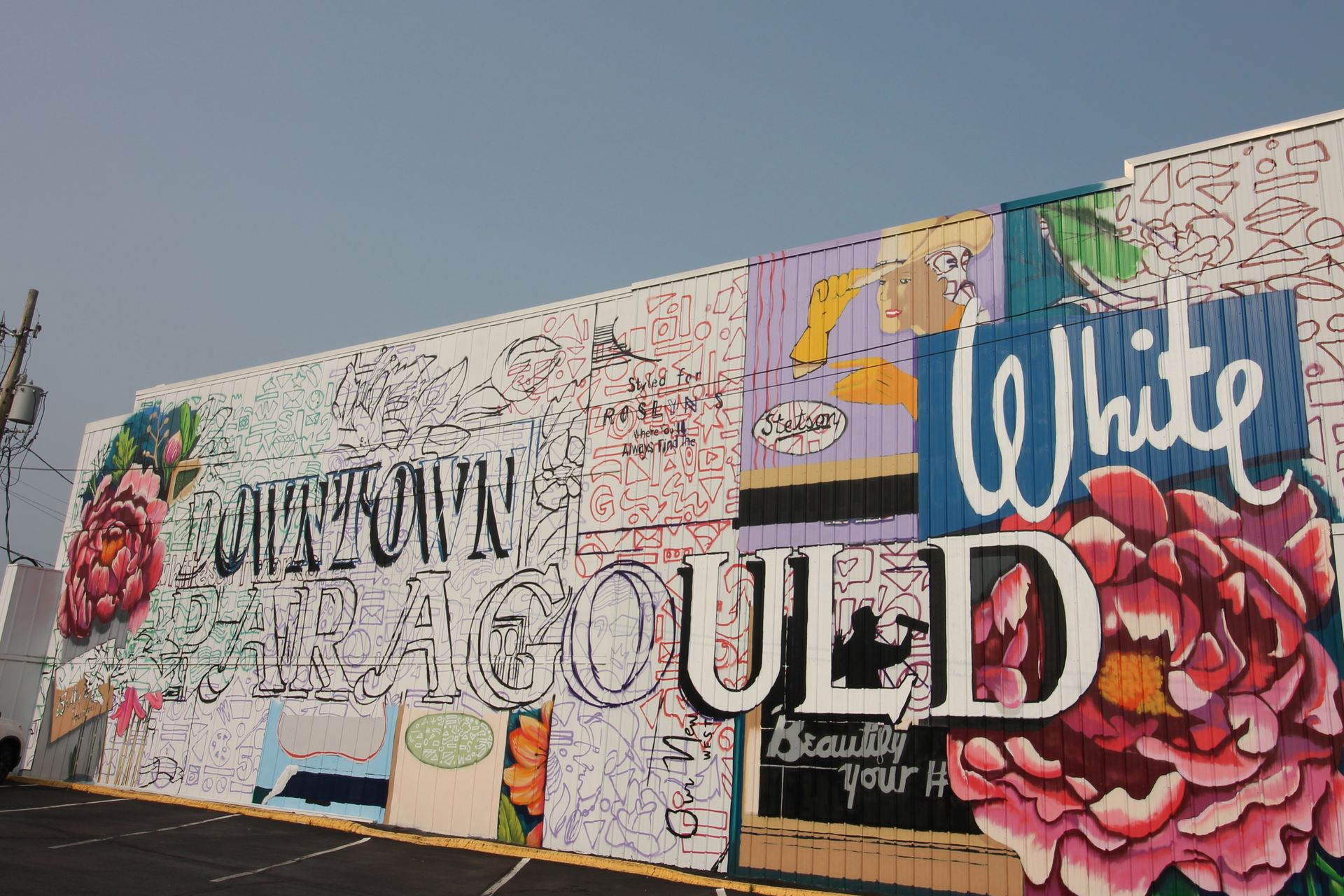 A mural on the side of a building that says white could