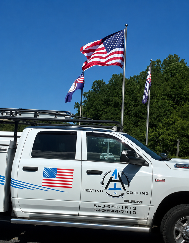 White pickup truck with American flags on the side and roof, parked outdoors under a blue sky.