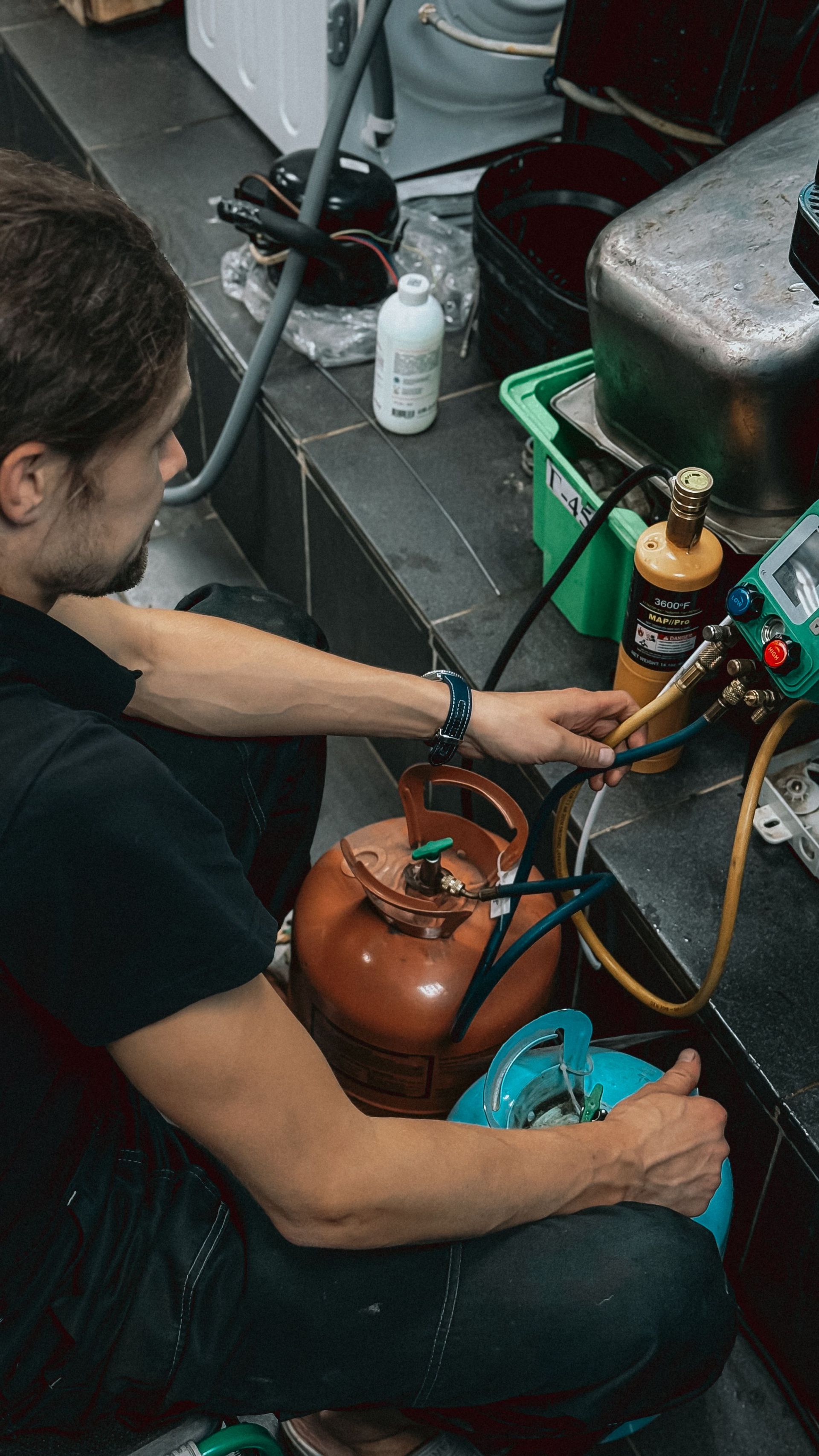 Technician inspecting outdoor electrical panels beside a house