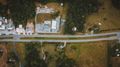 Aerial view of a quiet neighborhood with houses, streets, trees, and mountains at sunset