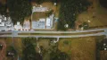 Aerial view of a quiet neighborhood with houses, streets, trees, and mountains at sunset
