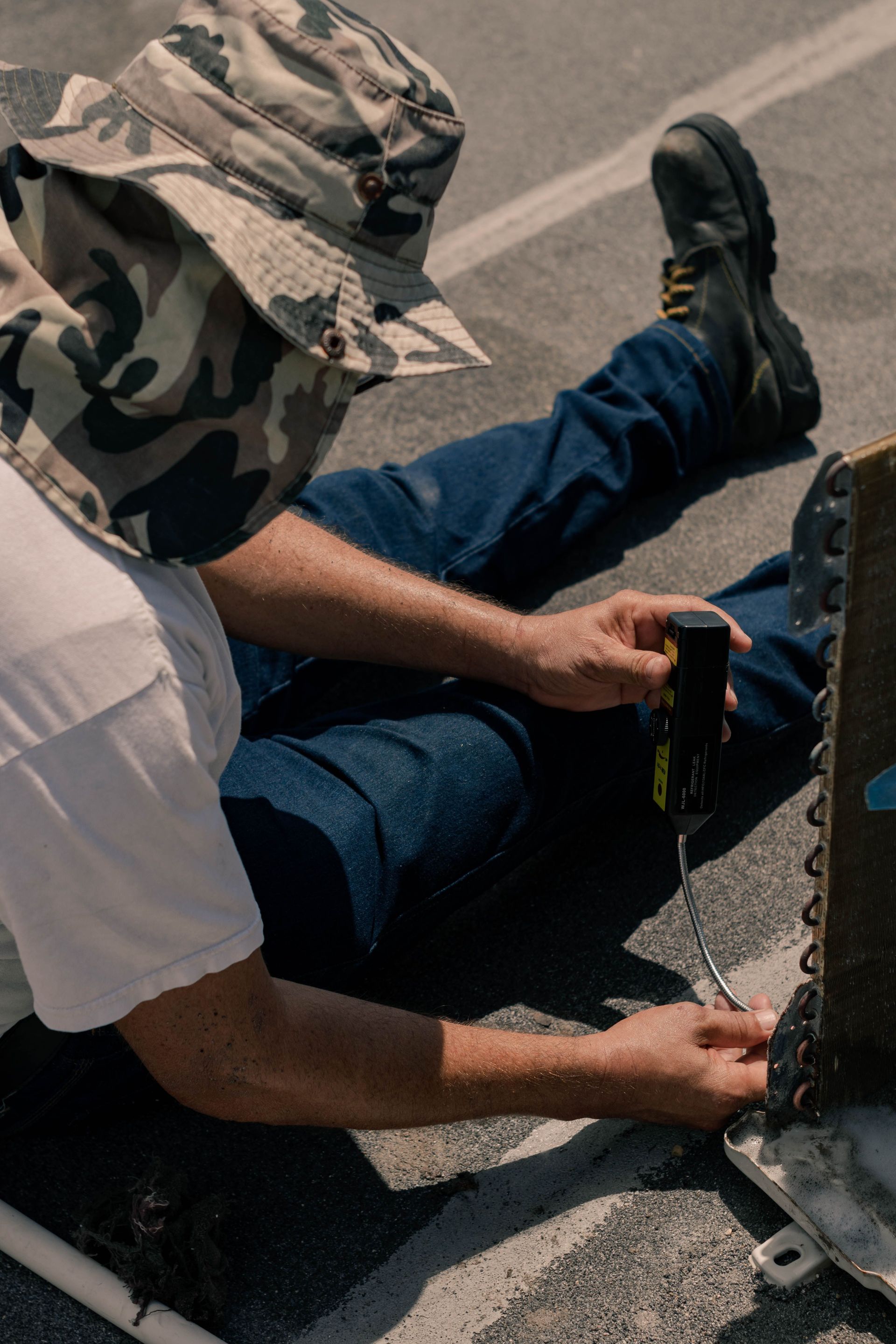Technician inspecting outdoor electrical panels beside a house