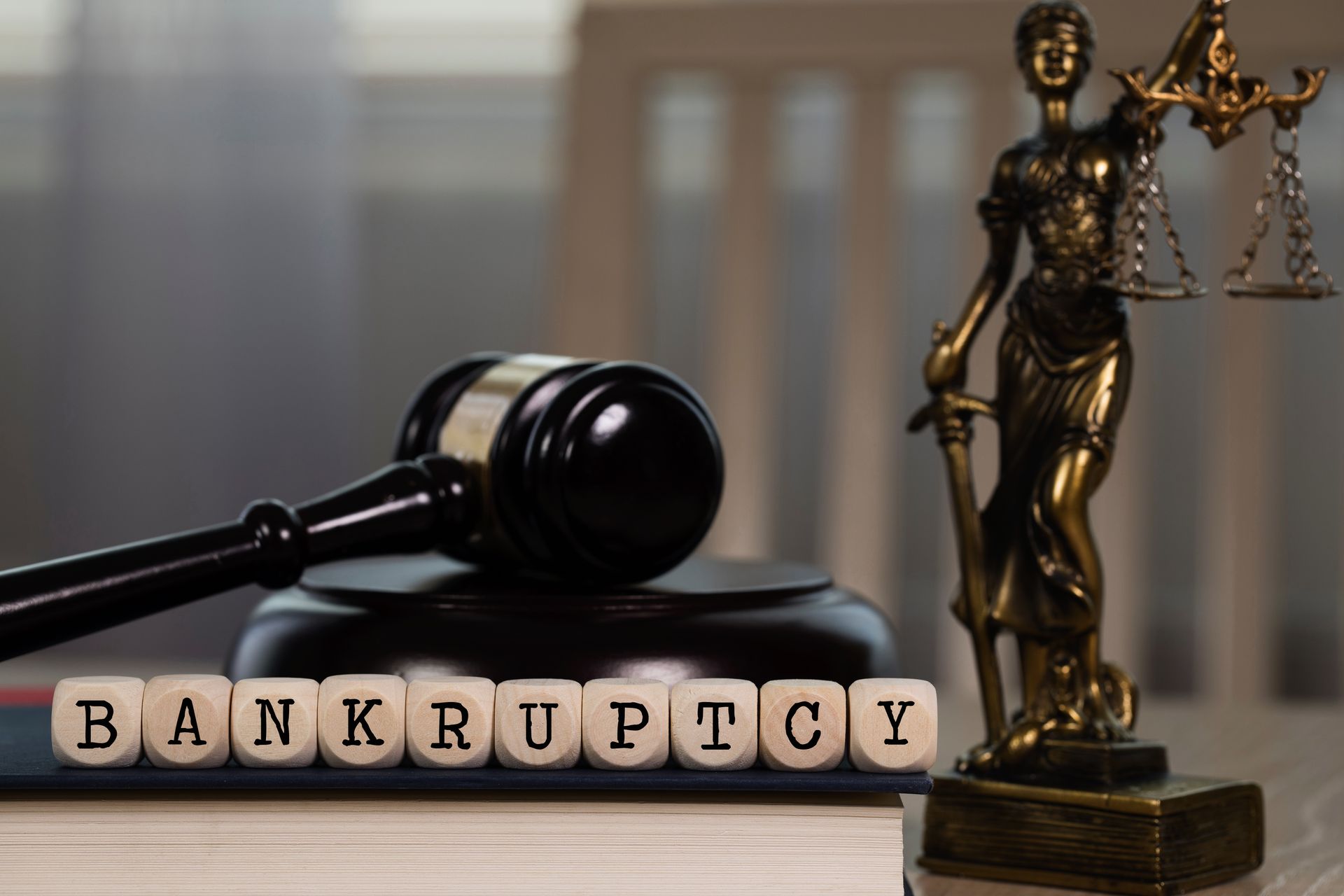 Gavel and Lady Justice statue next to blocks spelling