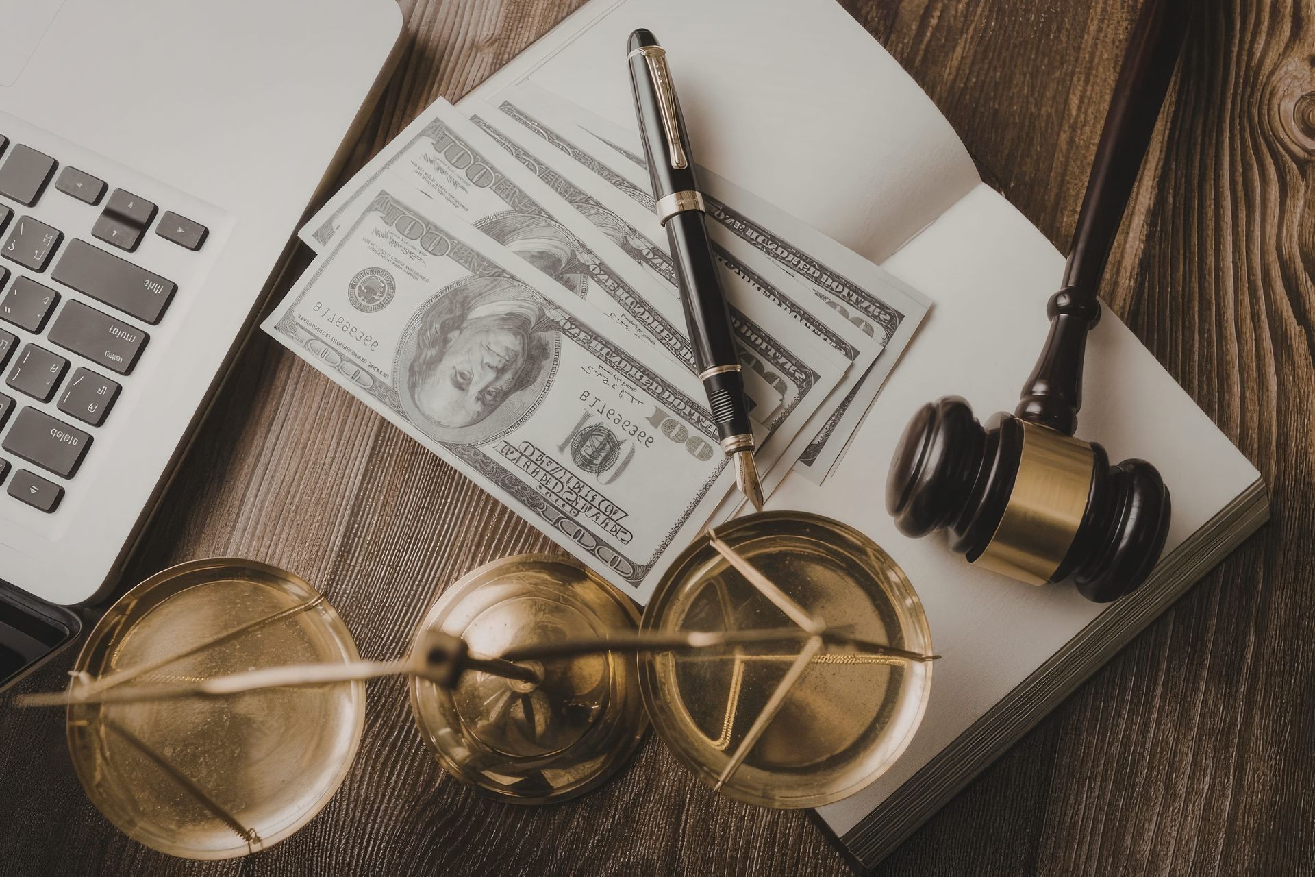 Gavel, scales, calculator, and cash on a desk, suggesting finance or legal work