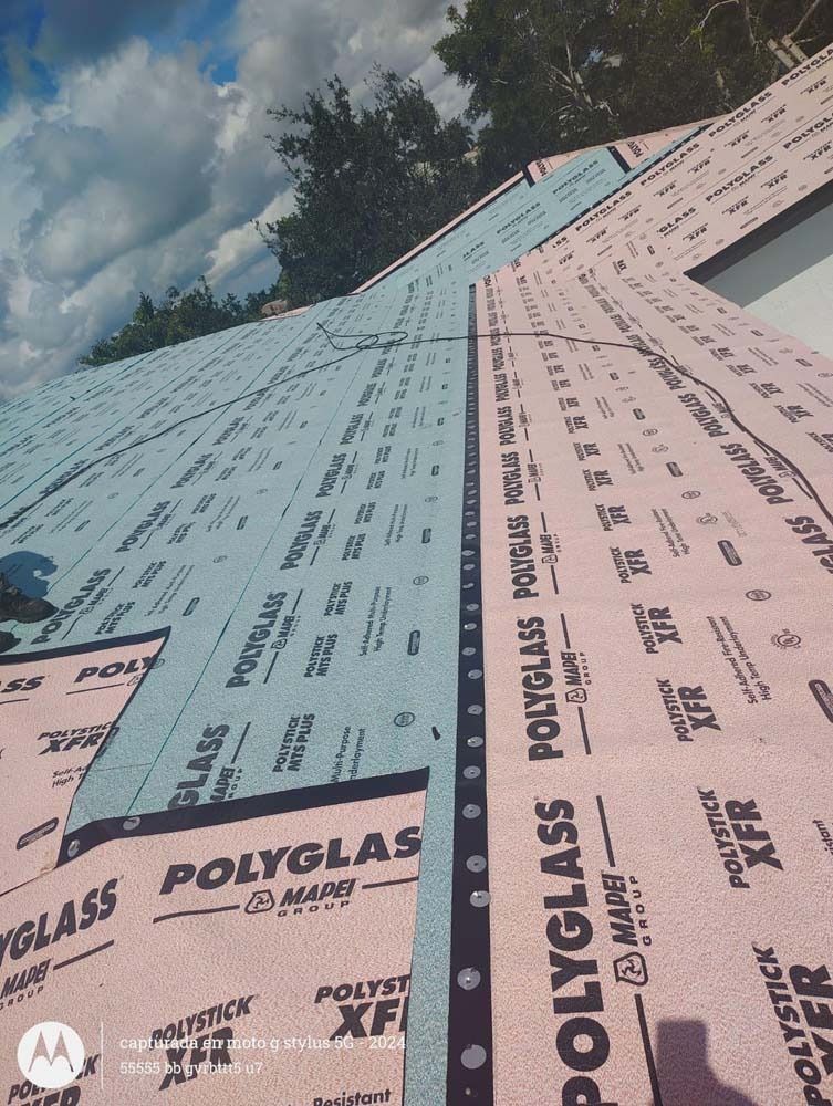 A roof under construction featuring layers of pink and blue Polyglass underlayment material.