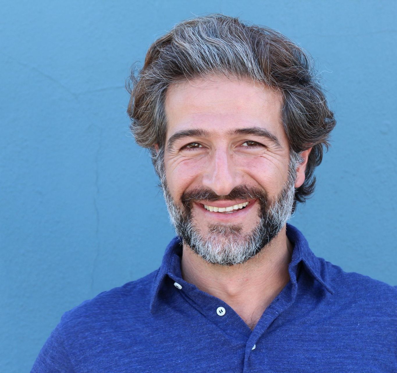 guy outside smiling showing teeth looking at the camera
