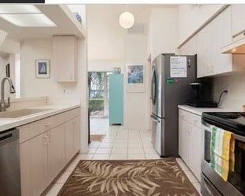 A picture of a newly renovated kitchen with new white tile floor.