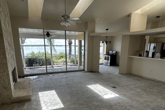 A picture of a spacious living room with the old flooring removed and before the new tile is installed.