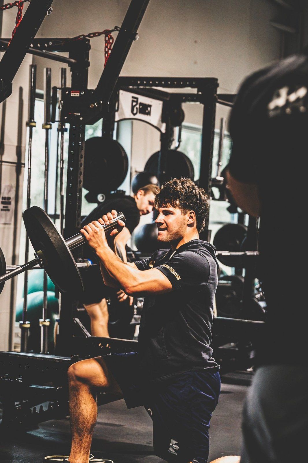 Focused hockey athlete performing a controlled strength exercise with a barbell in the Ghost Athletica gym Focused hockey athlete performing a controlled strength exercise with a barbell in the Ghost Athletica gym