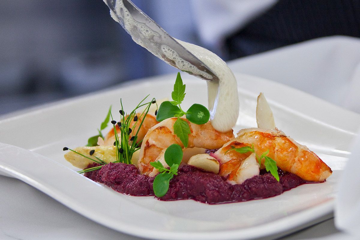 Eine Nahaufnahme von einem Teller mit Essen mit Garnelen und Soße