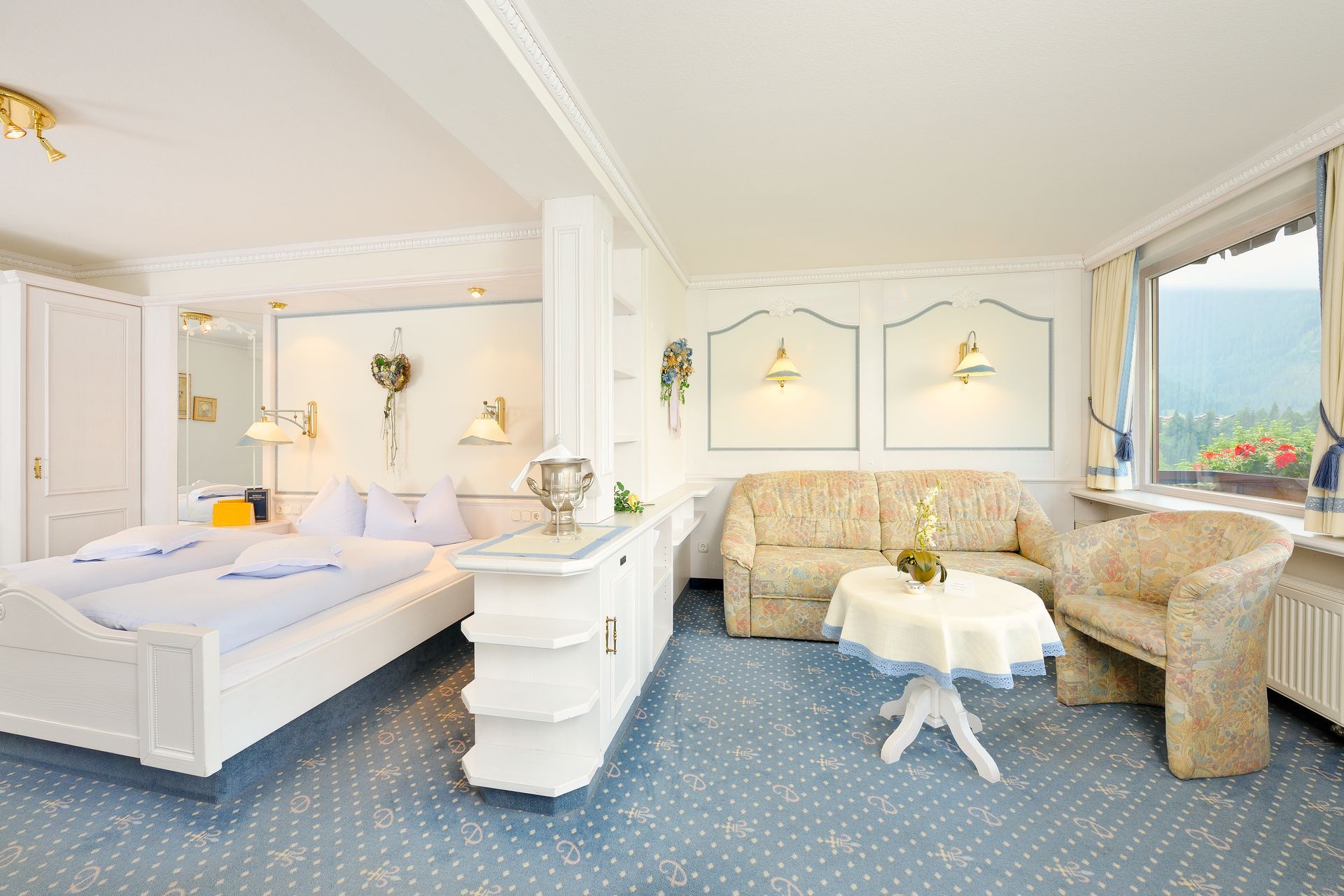 Ein Hotelzimmer mit Bett, Couch, Sessel und Tisch