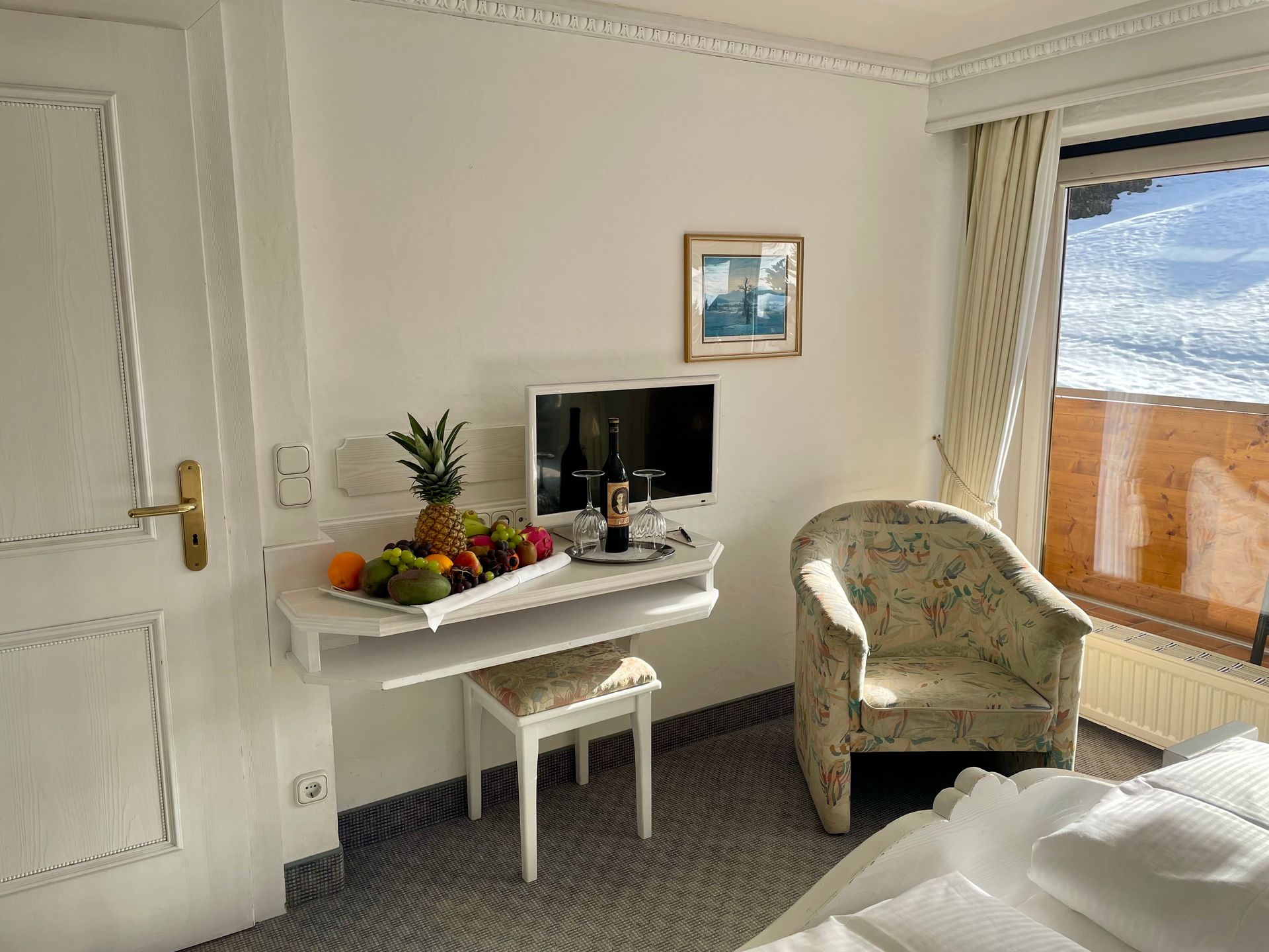 Ein Hotelzimmer mit Bett, Stuhl, Schreibtisch und Fernseher.