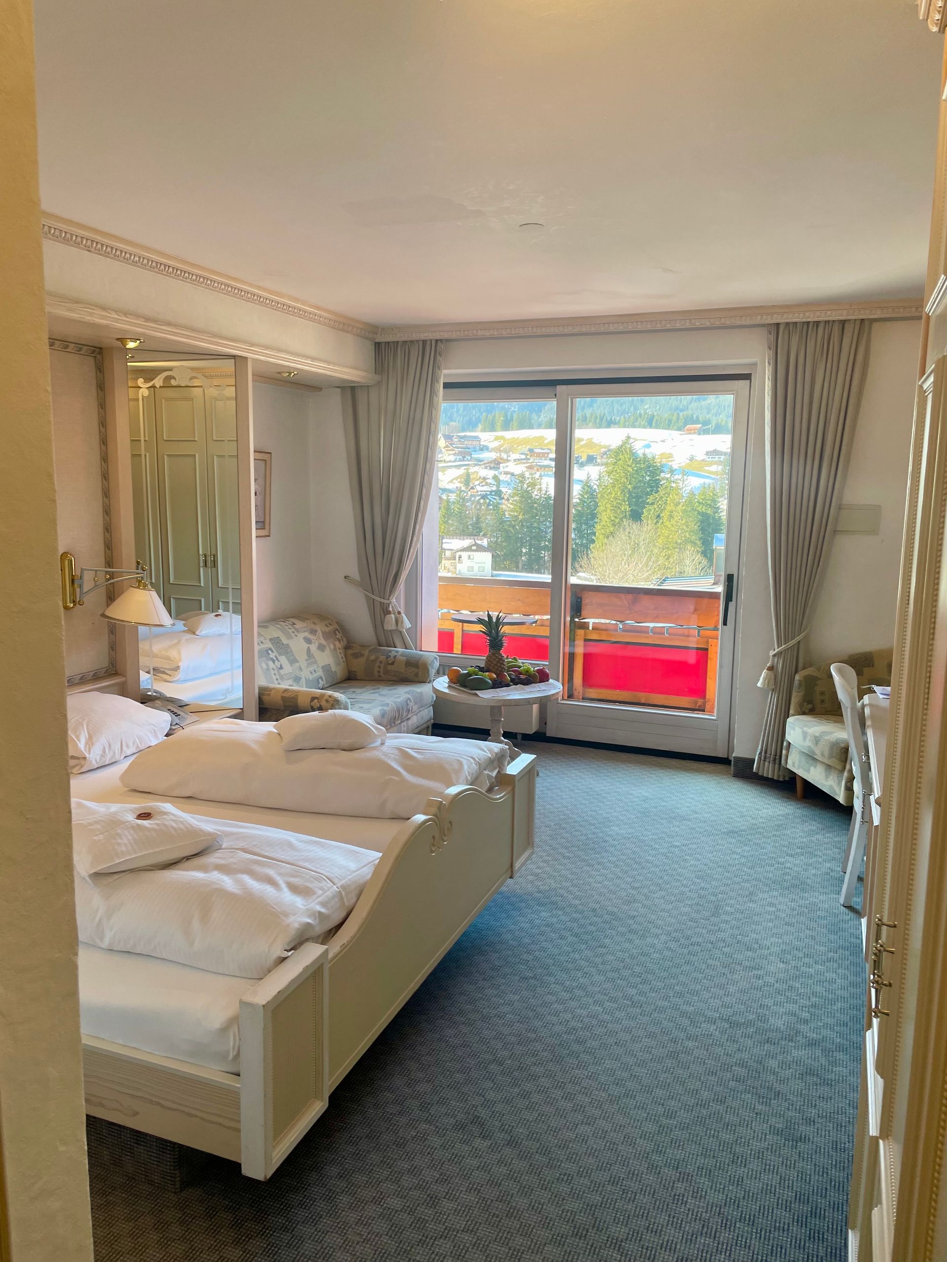 Ein Hotelzimmer mit zwei Betten, einer Couch und einem Balkon.