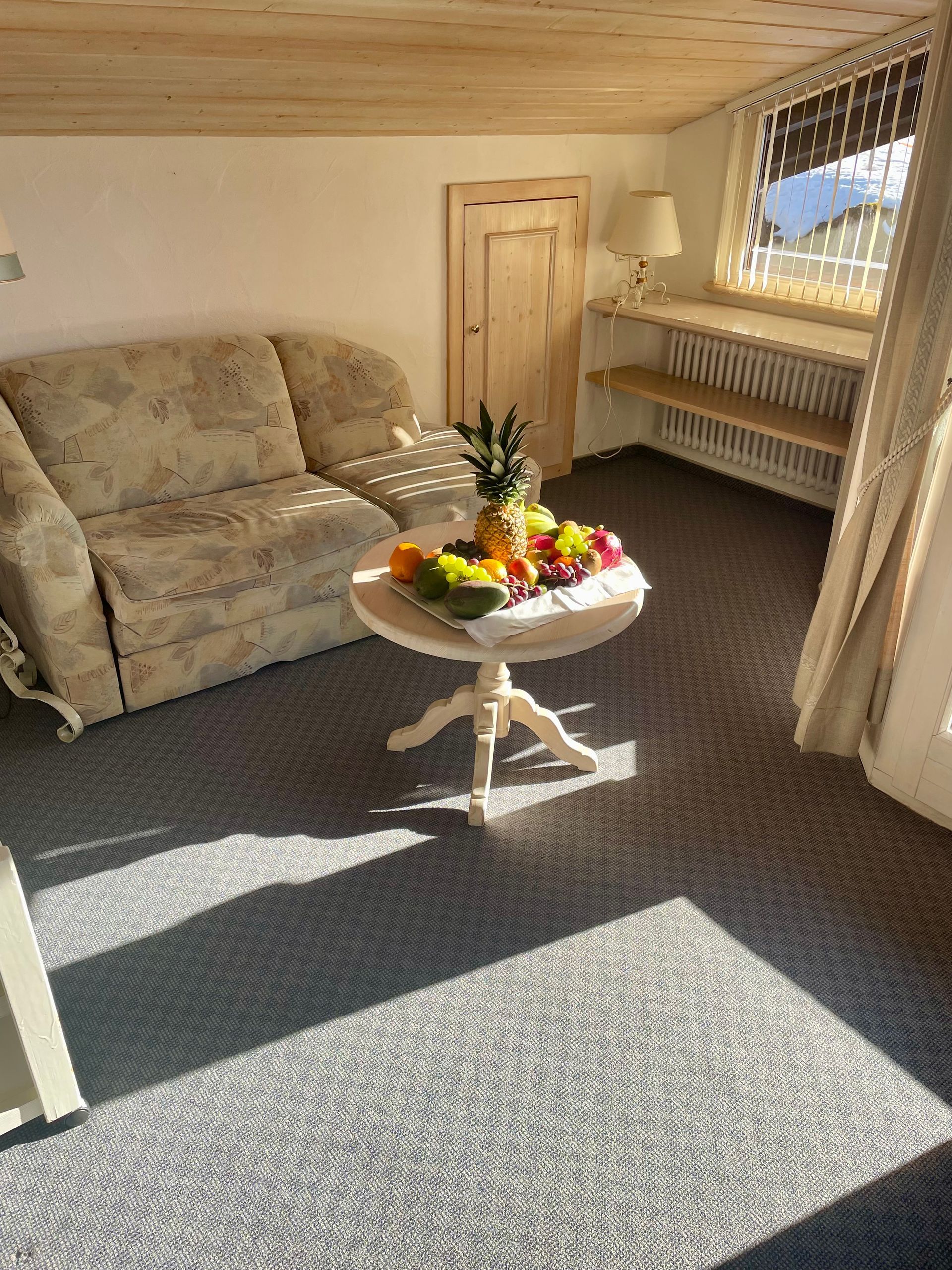 Ein Wohnzimmer mit einem Sofa und einem Tisch mit Obst darauf.