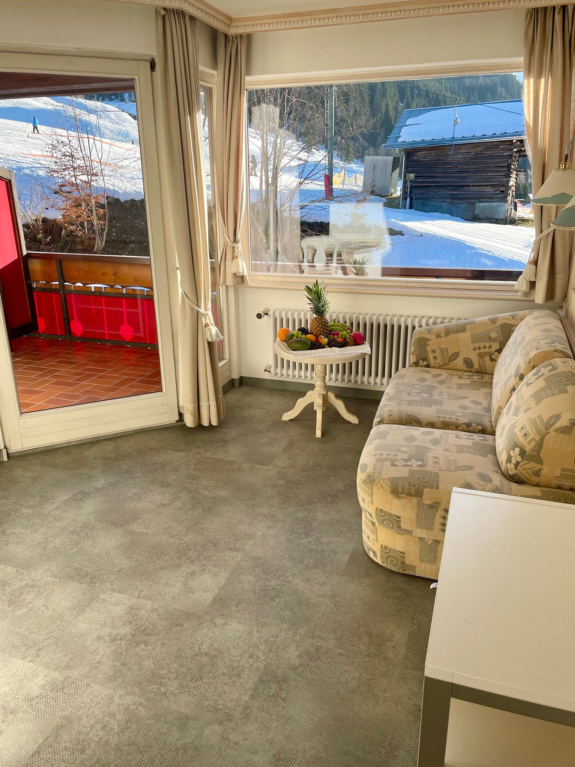 Ein Wohnzimmer mit einem Sofa und einem Tisch mit Obst darauf.