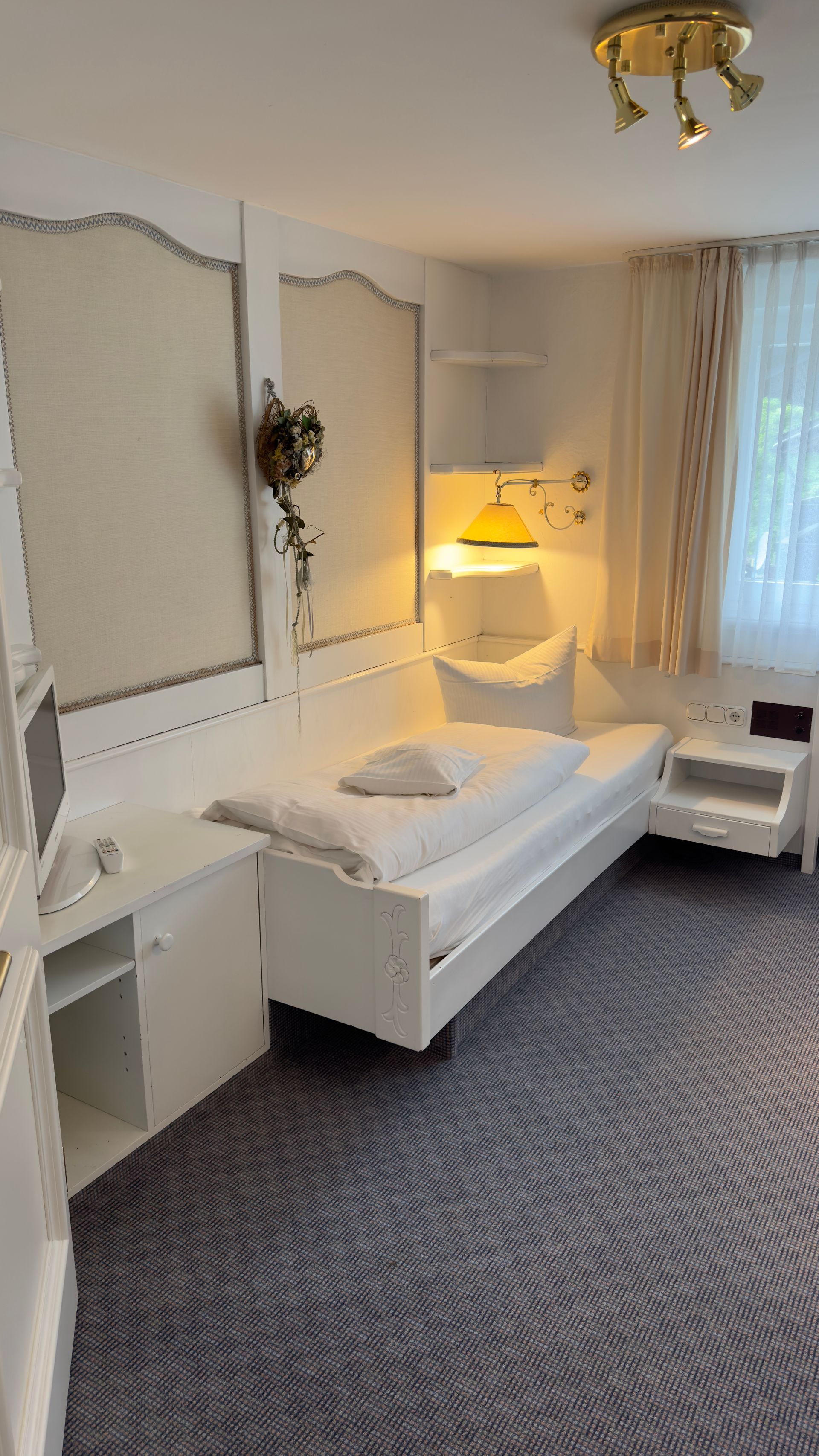 In der Mitte des Zimmers steht ein Einzelbett.