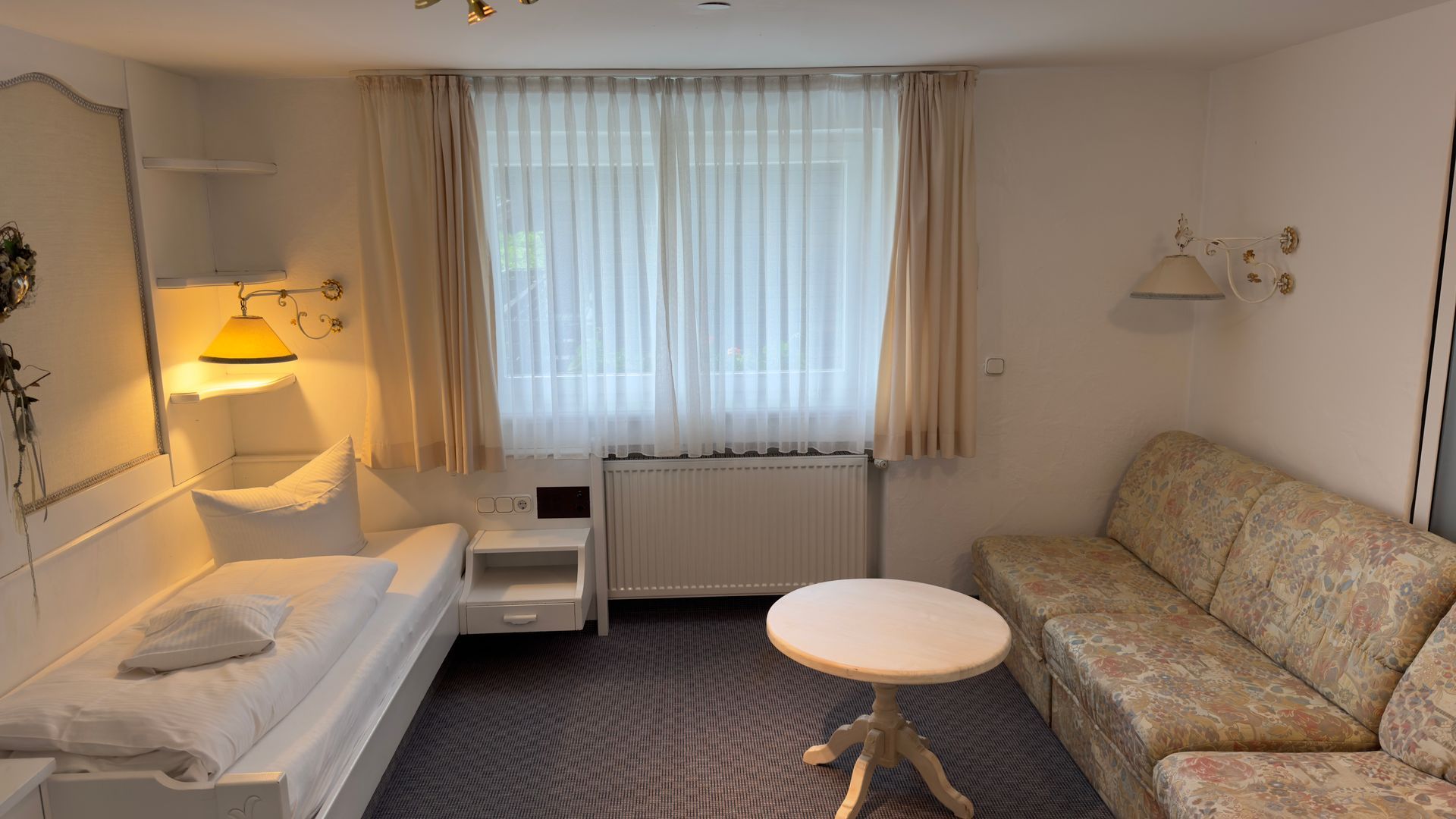 Ein Wohnzimmer mit Couch, Tisch und Bett.