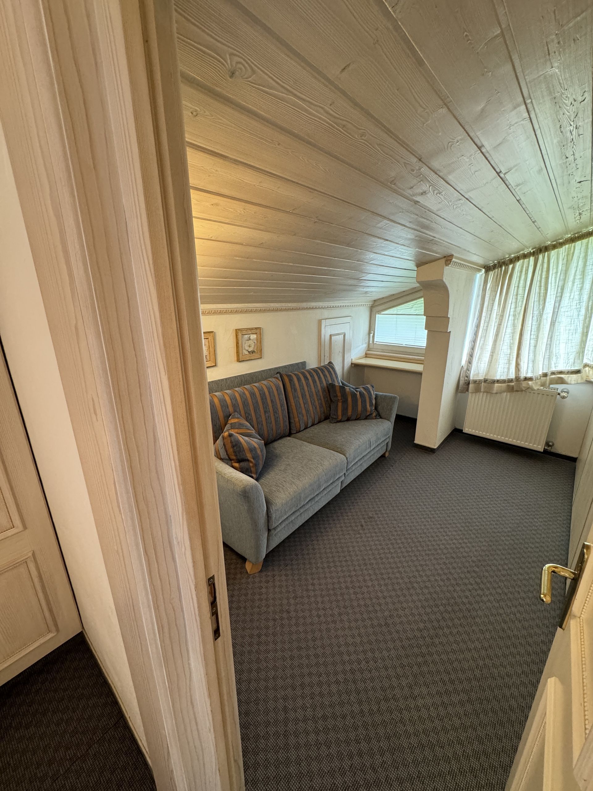Ein Wohnzimmer mit einer Couch und einem Fenster.