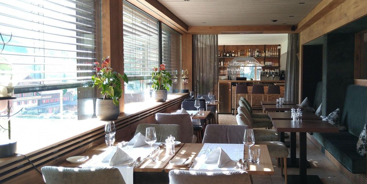 Ein Restaurant mit Tischen und Stühlen vor einem Fenster.
