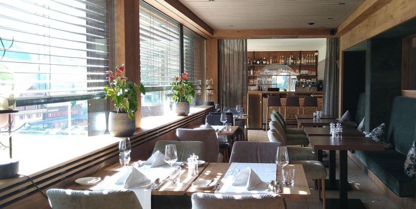 Ein Restaurant mit Tischen und Stühlen vor einem Fenster.