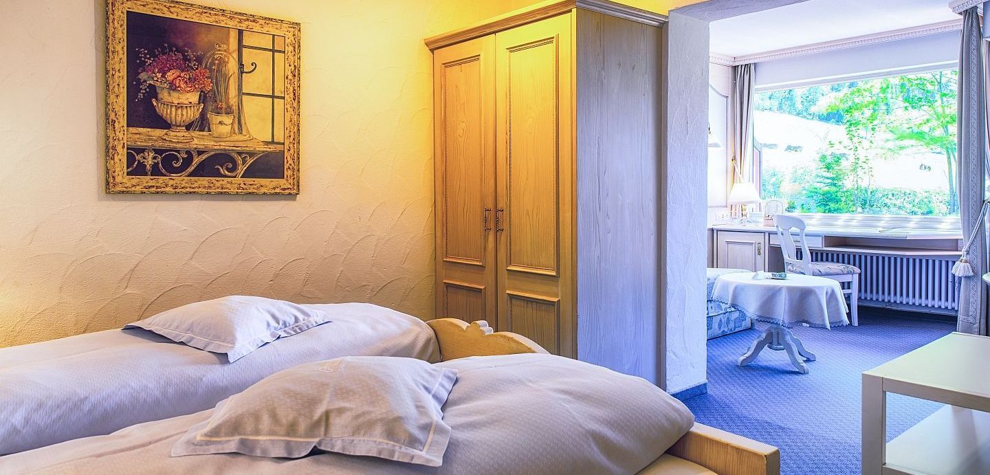 Ein Schlafzimmer mit zwei Betten und einem Gemälde an der Wand