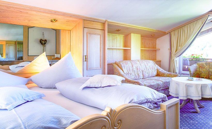 Ein Hotelzimmer mit zwei Betten, einer Couch und einem Tisch.