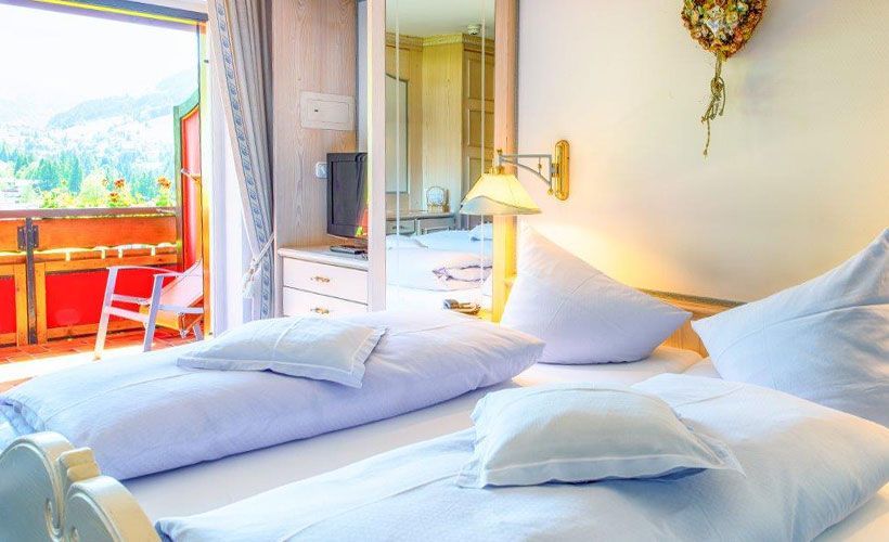 Ein Schlafzimmer mit zwei Betten und einer Uhr an der Wand.