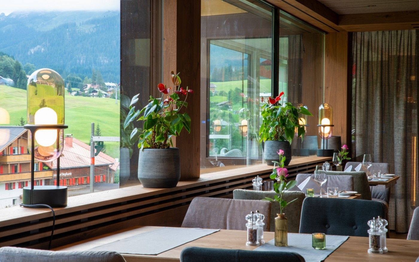 Ein Restaurant mit Tischen und Stühlen und einem großen Fenster mit Blick auf die Berge.