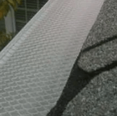 Close-up of a white textured metal ramp beside rough gray pavement and dark cracks