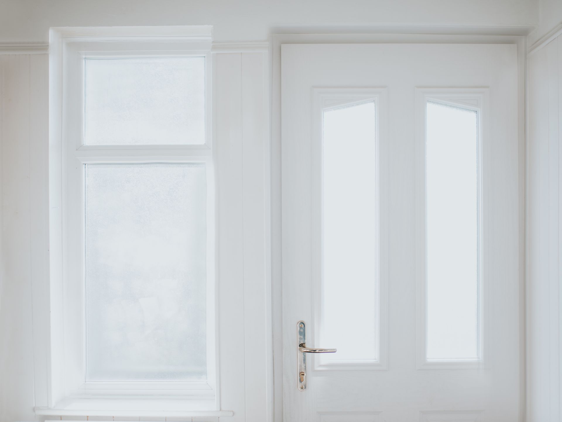 Picture of a white window and door at a residential property. Picture of a white window and door at a residential property.