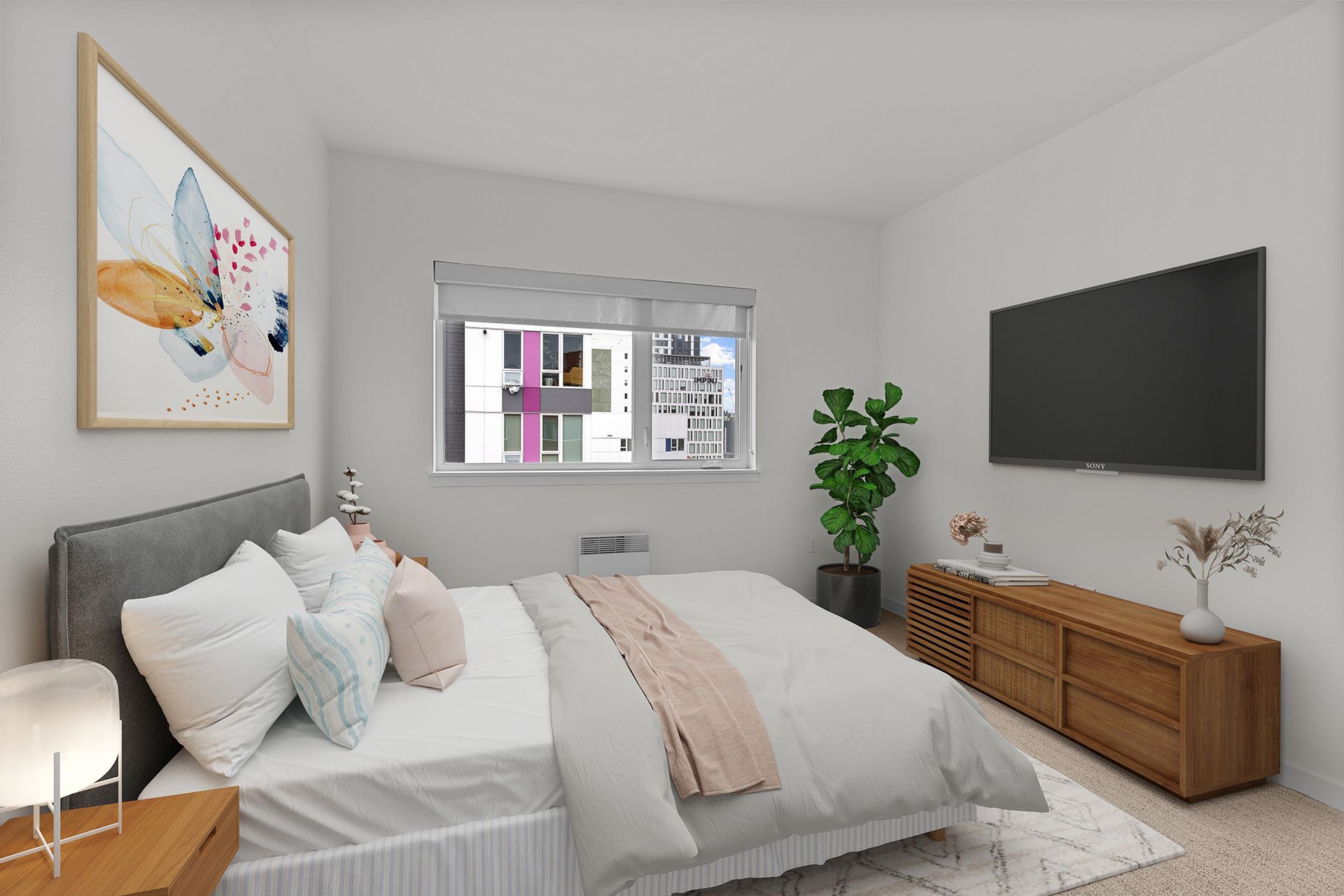 Bedroom with a bed, TV, and wooden dresser. A large window overlooks a cityscape, and art hangs on the wall.