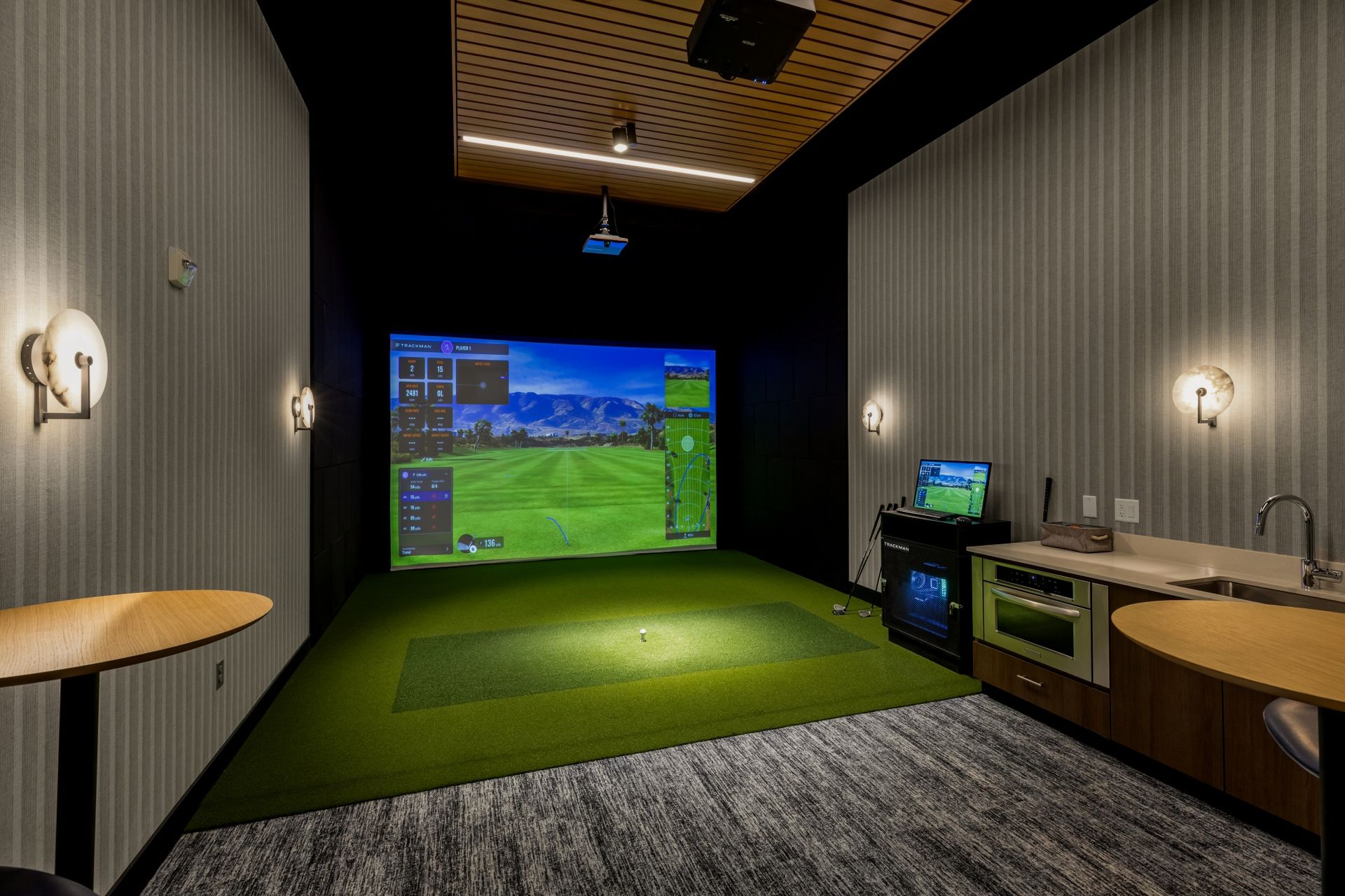 There is a golf simulator in the middle of the room.
