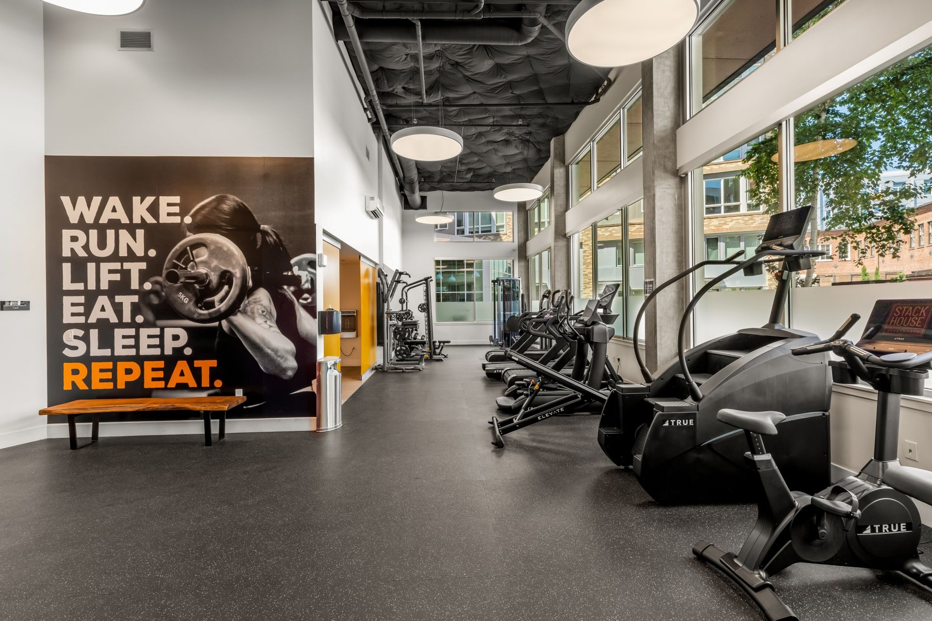 A gym with a sign that says wake run lift eat sleep repeat