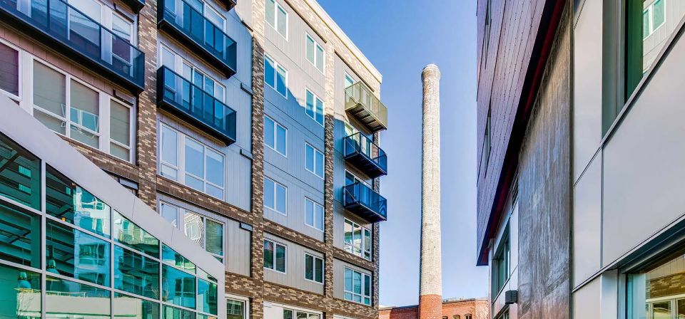 A building with a chimney in the middle of it is surrounded by other buildings at Stack House.