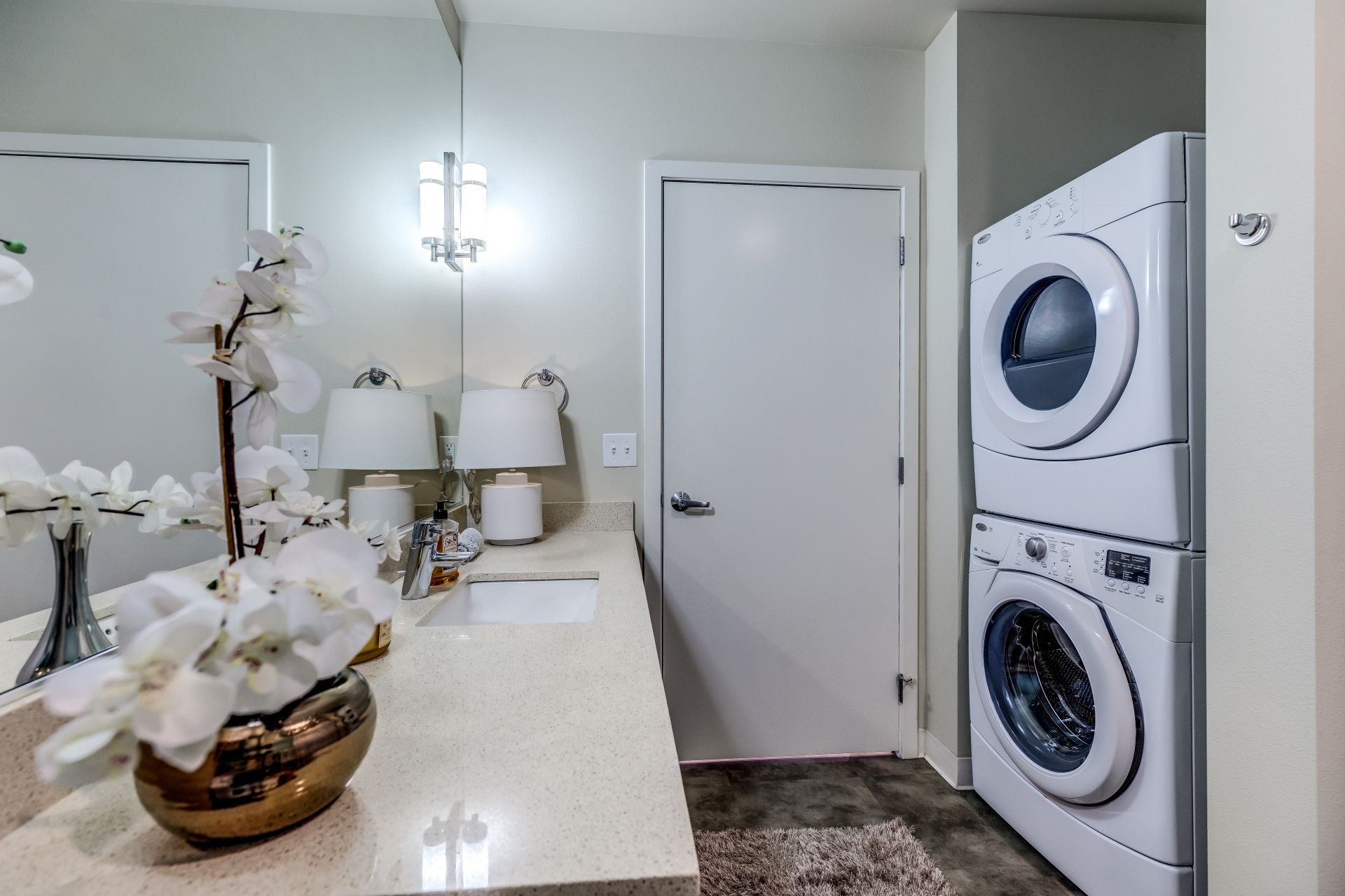 A bathroom with a washer and dryer stacked on top of each other at Stack House.