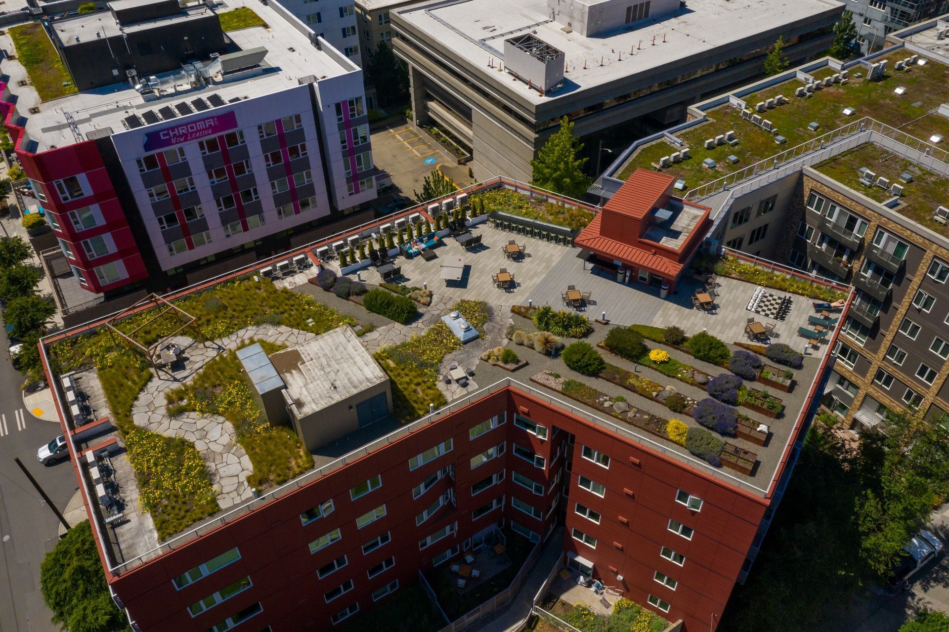 An aerial view of a city with lots of buildings and a green roof.