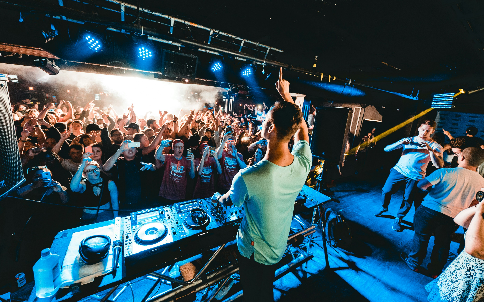A man is playing music on a stage in front of a crowd.