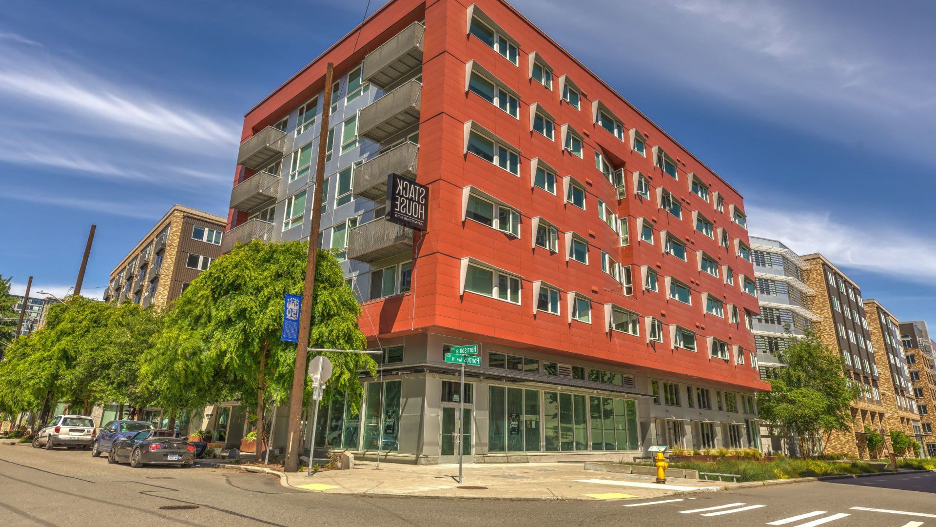 A large red building with a lot of windows is sitting on the corner of a city street at Stack House.